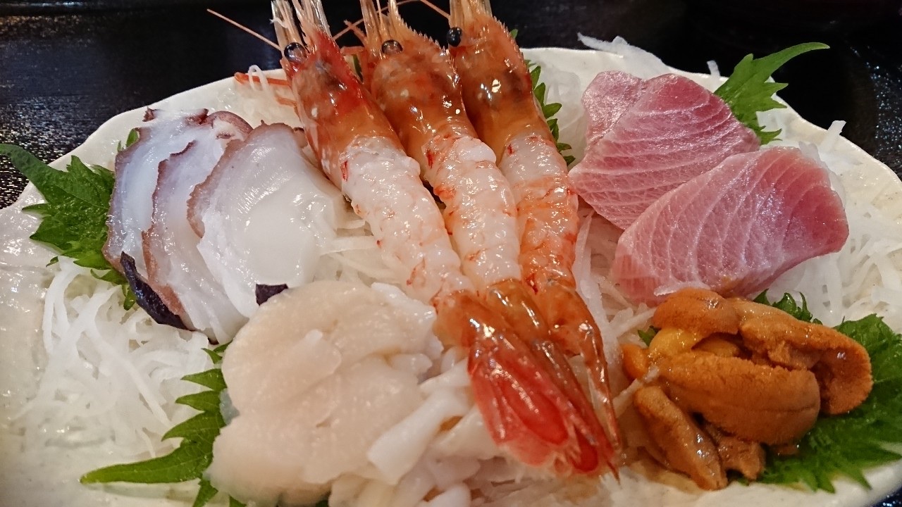 A rice bowl topped with fresh seasonal seafood, including uni.